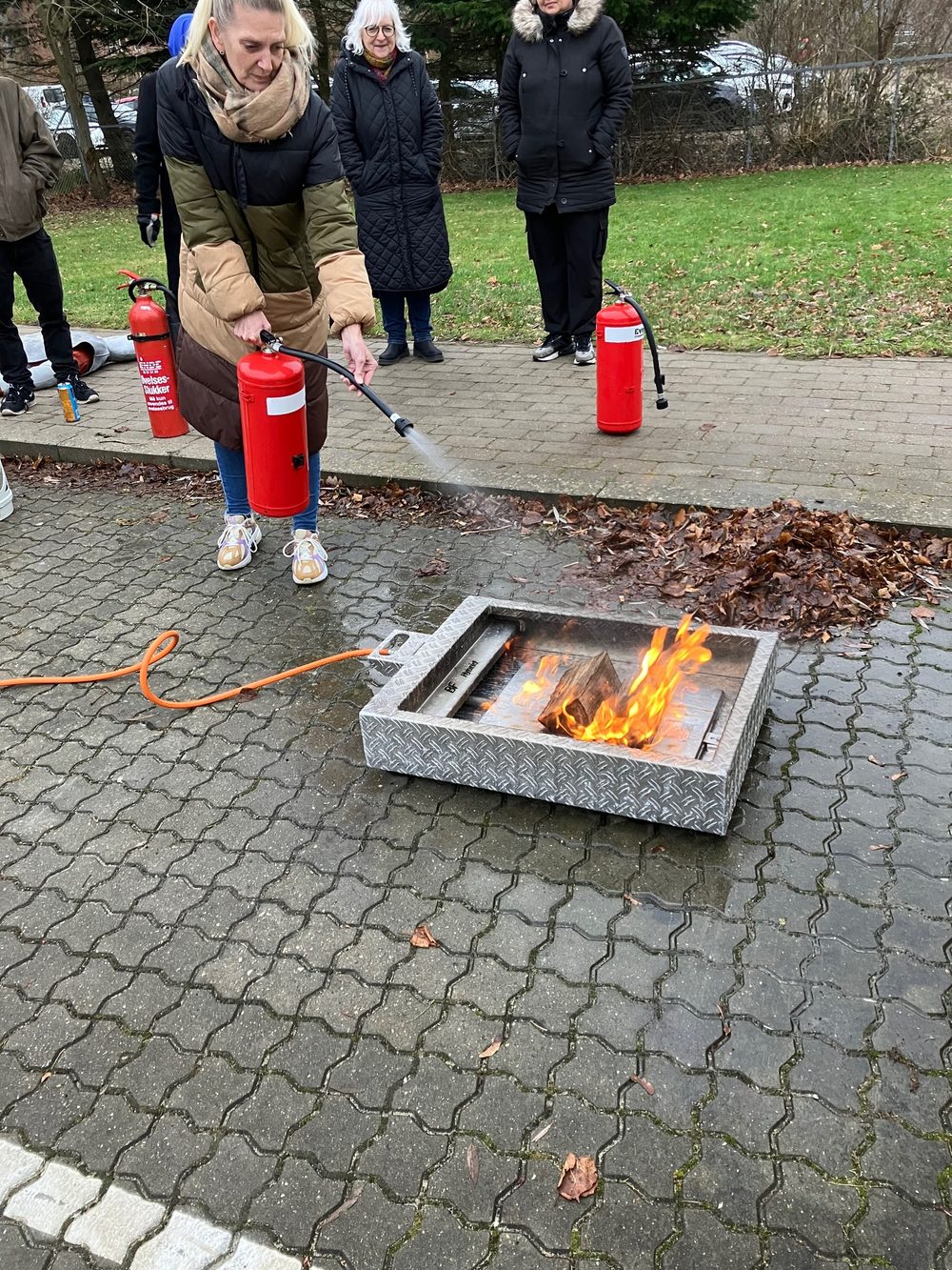 Deltager slukker ild med brandslukker